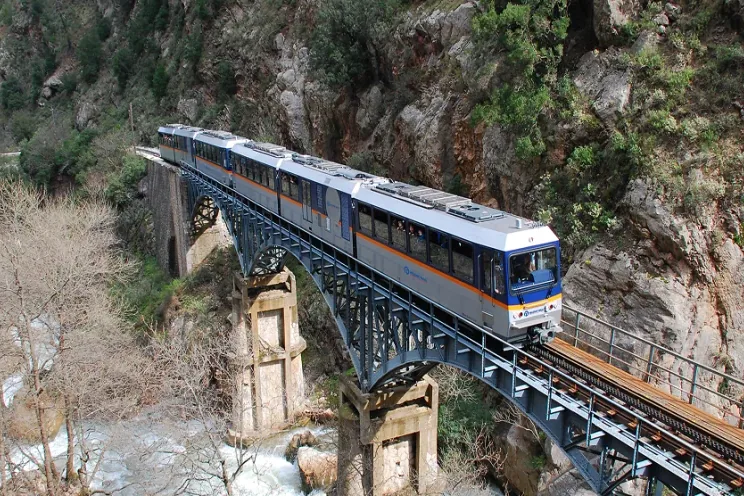Ο συρμός του Οδοντωτού πάνω σε σιδερένια γέφυρα, μέσα στο φαράγγι του Βουραϊκού